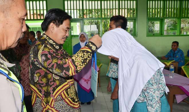 SIMBOLIS: Wabup Sidoarjo H Nur Ahmad Saifuddin simbolis melepas tanda peserta pada dua siswa kala penutupan MPLS SMA Budi Utomo Prambon Sidoarjo, Kamis (21/7). foto: MUSTAIN/ BANGSAONLINE