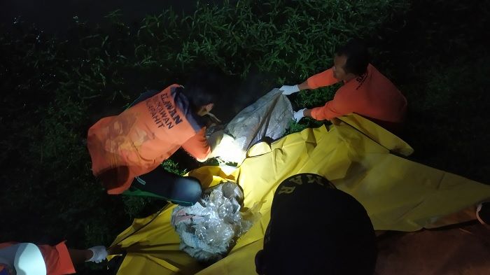 Proses evakuasi potongan tubuh dalam karung oleh petugas. Foto: AAN AMRULLOH/ BANGSAONLINE