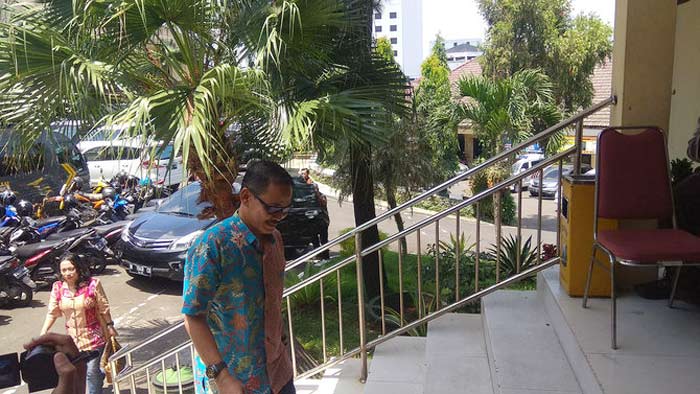 Hadi Susanto, salah satu saksi dari PDI P, disusul seorang anggota DPRD perempuan di belakangnya, saat memasuki aula Rupatama Mapolres, tempat penyidik KPK berada, Senin (19/3).
