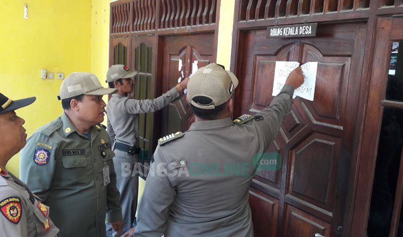 Trantib Kecamatan Manyar melepas segel di ruang kerja Kades Sukomulyo. foto: SYUHUD/ BANGSAONLINE