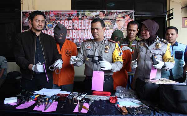 Petugas saat menunjukkan kedua pelaku dan barang bukti. (foto: rusmiyanto/BANGSAONLINE)