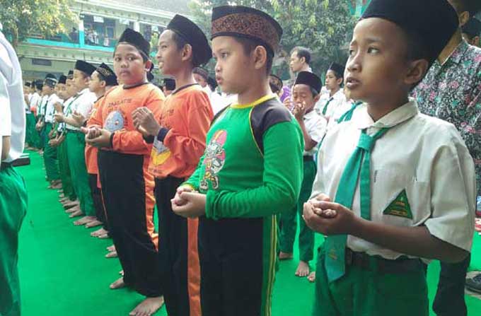 Sejumlah pelajar di MI Nurul Huda 2 Surodinawan melaksanakan salat gaib untuk mendoakan umat Islam Rohingya di Myanmar, Selasa (5/9/2017). foto: ROCHMAD ARIS/ BANGSAONLINE