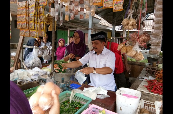 Gus Syaf melayani warga yang hendak belanja di lapak milik Ningsih. Foto: BANGSAONLINE
