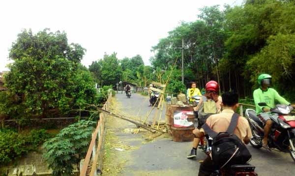 Warga setempat memberi rambu seadanya di bagian jembatan yang berlubang. foto: dendi martoni/BANGSAONLINE