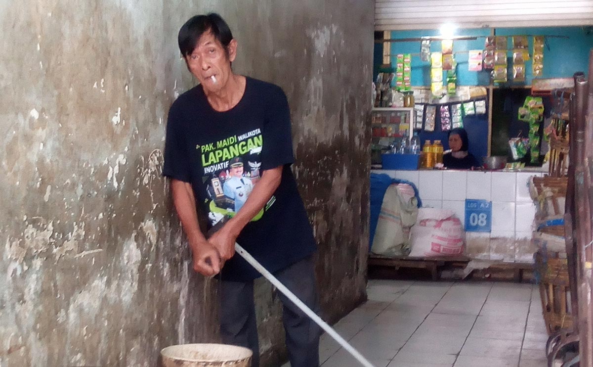 Cara Pujianto memeras peralatan pel yang digunakan untuk membersihkan lantai PBM masih manual menggunakan tangan. Foto: HENDRO SUHARTONO/ BANGSAONLINE