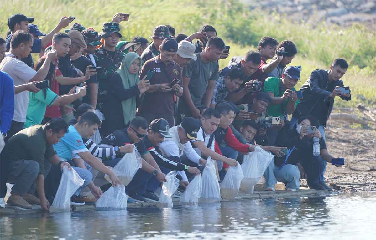 Pj Bupati Nganjuk saat melepaskan bibit ikan di Bendungan Semantok. 