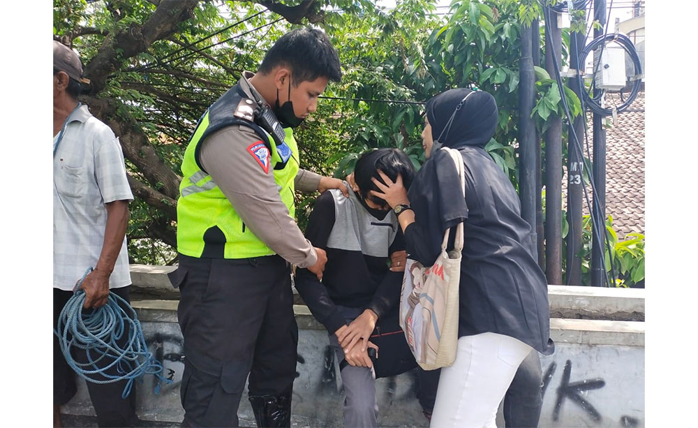 Petugas kepolisian saat menenangkan pelaku percobaan bunuh di Jembatan Bandar Lor. Foto: Ist.