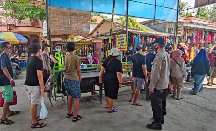 Petugas Polres Gresik memeriksa para pengunjung yang hendak masuk ke Pantai Delegan, Panceng. foto: ist.