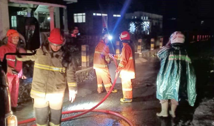 Tim SAR dibantu warga membersihkan material lumpur dan sampah yang menggenangi jalan, Senin (10/2) malam.