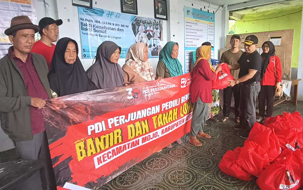 Ketua DPC PDIP Kabupaten Kediri, Murdi Hantoro, saat menyerah bantuan secara simbolis kepada salah satu warga. Foto: MUJI HARJITA/ BANGSAONLINE