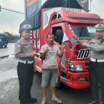 Anggota Satlantas Polres Ngawi saat membagikan bendera merah putih kepada pengendara truk.