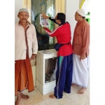 Anggota Fraksi Gerindra, Hafiluddin Faqih dan tokoh masyarakat Mahfud saat menempel stiker di masjid di dusun Karanganom.