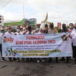 Peringati Hari Pers Nasional (HPN) 2021, PWI Ngawi bersama Kapolres Ngawi menggelar bagi-bagi masker dan hand sanitizer di Perempatan Kartonyono Ngawi, Selasa (9/2/2021). (foto: ist)