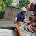 Proses evakuasi lansia yang terjebak di atas atap rumah. Foto: Ist.