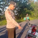 Petugas dari Polsek Gurah saat menunjukkan sepeda motor milik pelajar yang tewas. Foto: Ist
