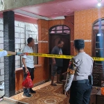 Petugas dari Polsek Kebomas saat melakukan olah TKP, dan memasang garis polisi di rumah korban. Foto: Ist
