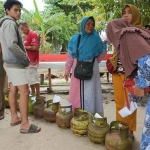 Warga saat menunggu antrean untuk membeli gas melon di kegiatan operasi pasar elpiji 3 kg yang dilaksanakan di Kantor Kelurahan Panarung, Kecamatan Pahandut, Kota Palangka Raya, Kalimantan Tengah, Selasa (18/2/2025). Foto: Kompas.com