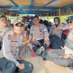 Kapolsek Buduran ketika menaiki perahu untuk membagikan makan siang bergizi ke sekolah di wilayah terpencil.