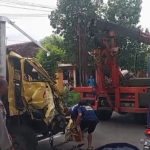 Truk boks yang ringsek diderek usai mengalami laka dengan truk pasir.