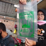 Ari Rahmawati menunjukkan hasil sablon kantong zakat plastik produksinya. foto: AAN AMRULLOH/ BANGSAONLINE