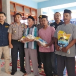 Ketua PWI Bachtiar Febriyanto dan Kapolres AKBP Feby Hutagalung saat menyerahkan bantuan beras ke nelayan.