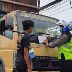 Petugas saat menilang kendaraan yang melanggar aturan.