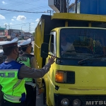 Petugas dari Satlantas Polres Batu saat menyekat salah satu truk pengangkut hewan ternak di Pos Simpang 3 Pendem.