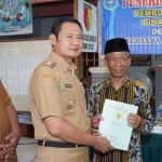 Bupati Lamongan, Yuhronur Efendi, saat menyerahkan sertifikat tanah kepada warga dari Kecamatan Deket.