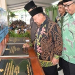 Mbah Tarom saat menandatangani prasasti.