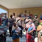 Wakapolres Kediri Kota Kompol Teguh Santoso dan jajaran saat berfoto bersama usai menyerahkan bantuan. (foto: ist)