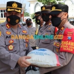 Kapolres Gresik, AKBP Mochamad Nur Azis (kiri) secara simbolis menyalurkan paket sembako kepada kapolsek. Foto: SYUHUD/BANGSAONLINE
