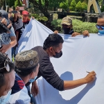 LSM Lira Kabupaten Probolinggo menggelar aksi penggalangan dukungan terhadap KPK dengan pembumbuhan tanda tangan di depan Kantor Bupati di Kraksaan Probolinggo, Selasa (31/8/2021). foto: Andi Sirajudin/ Bangsaonline.com