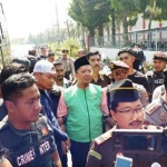 Ust Alfian Tanjung pakai kopiah dan rompi hijau, turun dari mobil tahanan kejaksaan. Dikawal aparat Kejati dan Kapolresta Sidoarjo.