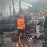Tim Damkar Kabupaten Gresik memadamkan api yang membakar mesin produksi PT Indospring. Foto: SYUHUD/ BANGSAONLINE