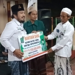 Wakil Ketua DPRD Bangkalan Khotib Marzuki menyerahkan bantuan secara simbolis kepada Ketua Tanfidziyah MWCNU Kamal  Abdur Rasyid.