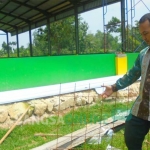 Agus Bashori menunjukkan besi proyek pengerjaan lapangan futsal di Desa Wonokerto Kecamatan Dukun yang diduga tak sesuai bestek. foto: SYUHUD/ BANGSAONLINE