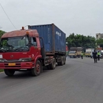 Petugas saat memeriksa truk pengangkut barang.