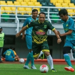 Wali Kota Surabaya Eri Cahyadi saat menggiring bola dikawal pemain Sidoarjo All Star dalam pertandingan uji coba lapangan Stadion GBT, Sabtu (13/3/21).
