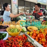 Erna, salah satu pedagang di Pasar Pahing, Kota Kediri, saat melayani pembeli. Foto: MUJI HARJITA/BANGSAONLINE