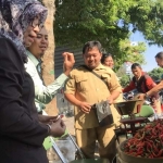 Kepala Disperindag Kota Kediri Yetty Sisworini bersama Ilyas petugas dari Bank Indonesia saat melayani pembeli. foto: ARIF KURNIAWAN/ BANGSAONLINE