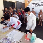Paslon Bupati dan Wakil Bupati Blitar Rijanto-Marhaenis Urip Widodo saat menandatangani berkas pendaftaran.