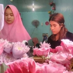 Salah satu pedagang saat merangkai bunga yang menjadi salah satu pernak pernik dalam perayaan hari valentine. foto: SYUHUD/ BANGSAONLINE