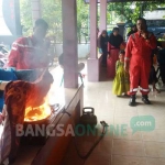 Salah satu warga saat mempraktekkan cara memadamkan kompor yang terbakar. foto: SUWANDI/ BANGSAONLINE