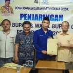 Ketua DPD Golkar Gresik, Ahmad Nurhamim menerima pengambilan formulir pendaftaran bakal cabup Tri Putro Utomo. foto: SYUHUD/ BANGSAONLINE