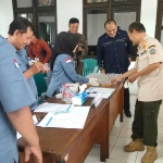 Kepala Satpol PP Gresik Agustin Halomoan Sinaga meninjau sampel urine anggotanya yang akan dilakukan rapid test. Foto: SYUHUD/ BANGSAONLINE