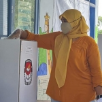 Salah satu warga saat menggunakan hak pilihnya di TPS 01 Martajasah, Kecamatan Bangakalan.