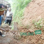 Tim Tagana Nganjuk dibantu polisi setempat membersihkan area longsor dari batu-batuan. foto: INTAN/ BANGSAONLINE