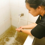 Seorang pelanggan menunjukkan air yang berwarna cokelat di bak mandi. foto: Puguh Sujiatmiko/Jawa Pos