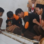 SIMULASI: Siswa MTs Hasanuddin memberikan pertolongan pertama pada korban saat simulasi tanggap bencana gempa bumi, Jumat (26/4). Foto: MUSTAIN/ BANGSAONLINE