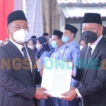 Bupati Gresik, Fandi Akhmad Yani, saat menyerahkan SK Pelantikan kepada Moh Nadlelah selaku kepala dinas kelautan dan perikanan. Foto: SYUHUD/BANGSAONLINE